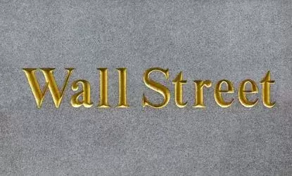 Wall Street in gold on brick background